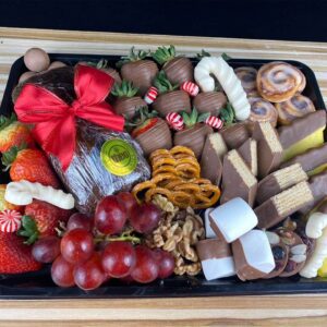 Plato surtido con fresas con chocolate, queque navideño, uvas, pretzels, rollos de canela, piñas, chocolates y nueces; Ideal para 6 personas aproximadamente.