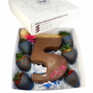 Caja con el número 5 en chocolate para quebrar con su respectivo martillo, relleno de gomitas y alrededor decorado con fresas cubiertas con chocolate